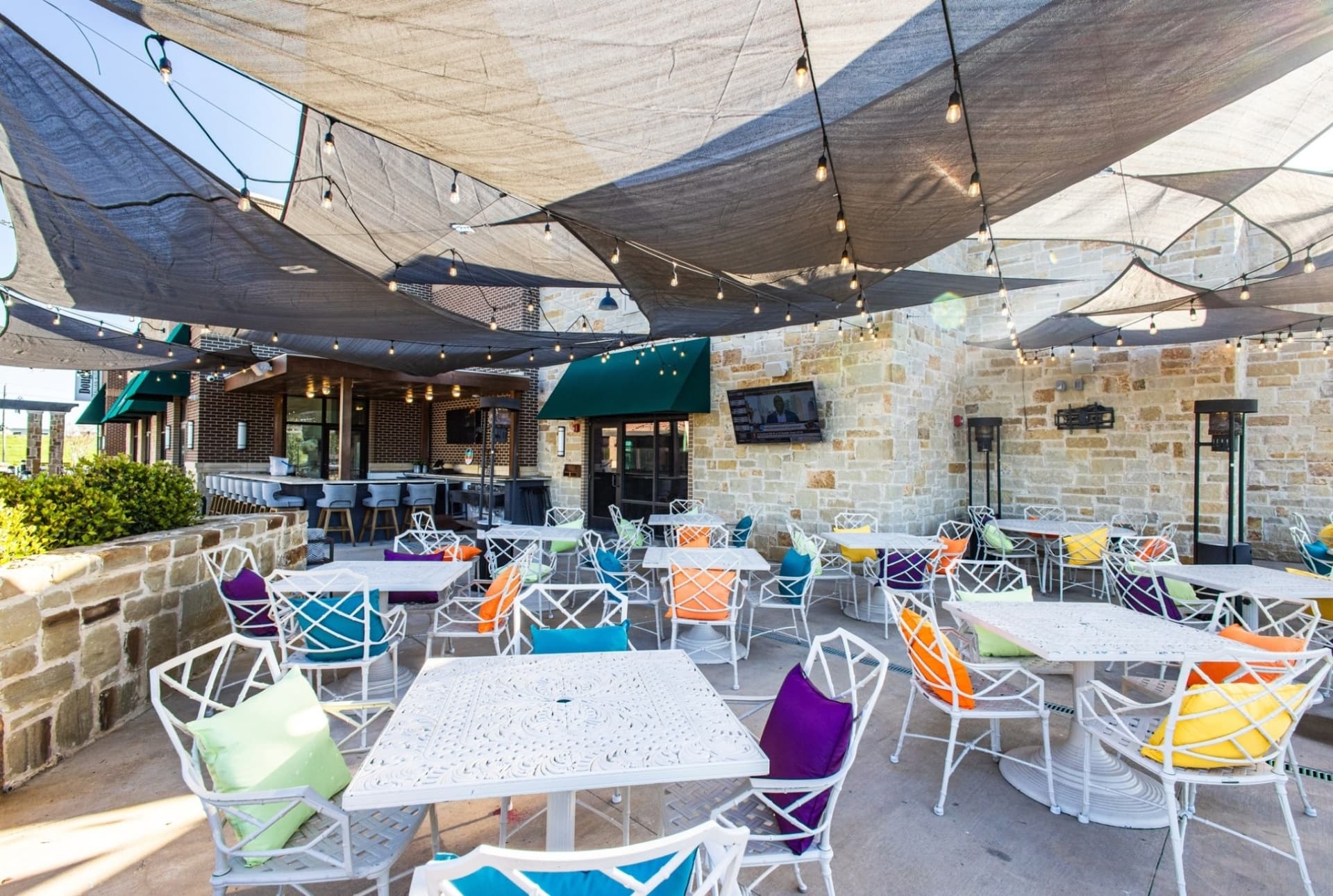 Outdoor patio with shade sails and string lights