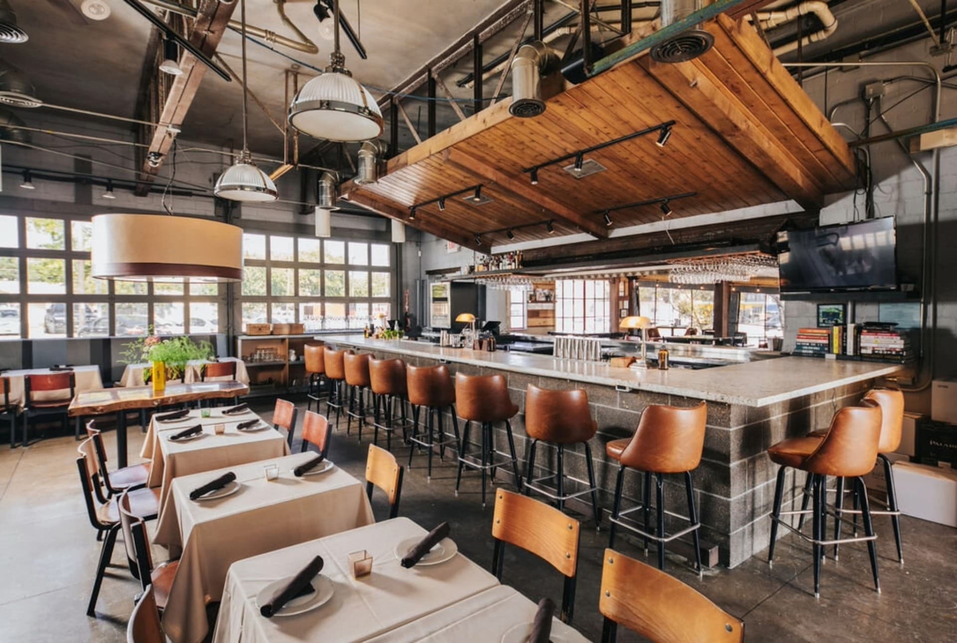 Encina restaurant bar area with leather stools and wood ceiling