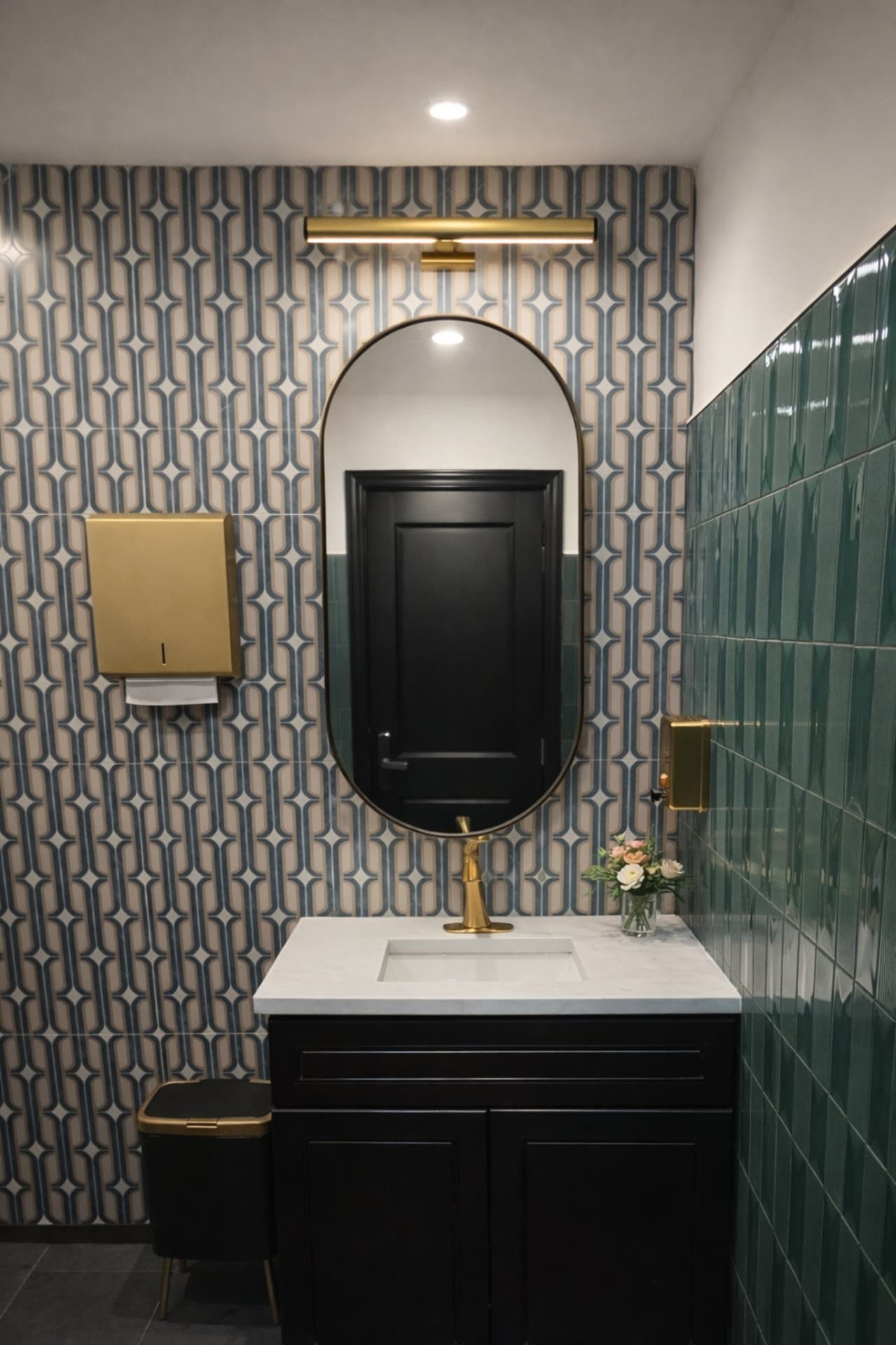 Prego Pasta House restroom vanity with oval mirror and brass lighting
