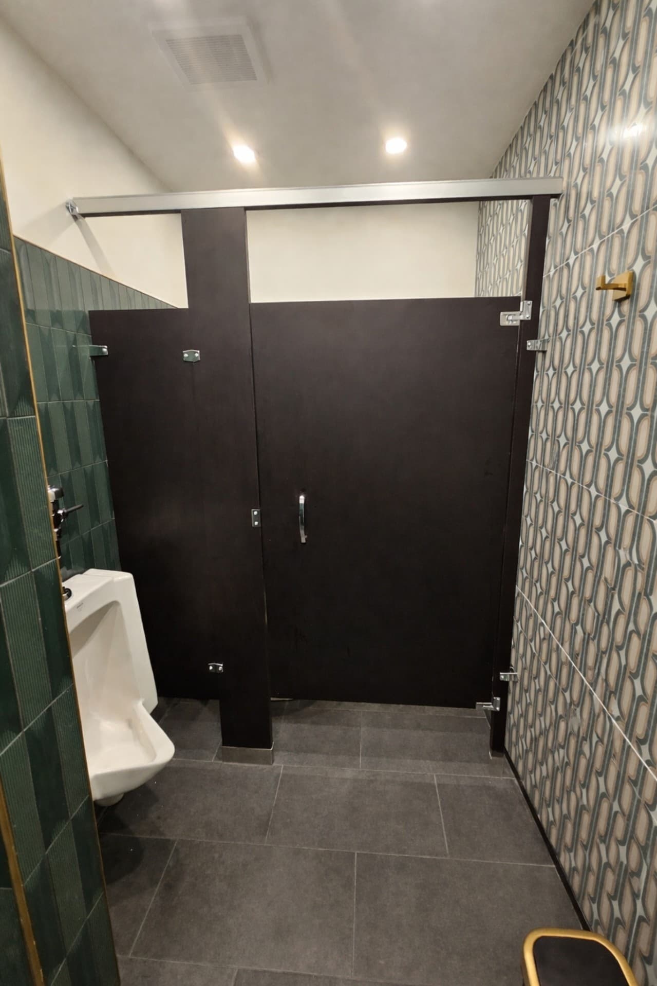 Prego Pasta House men's restroom with partitions and pattern tile wall