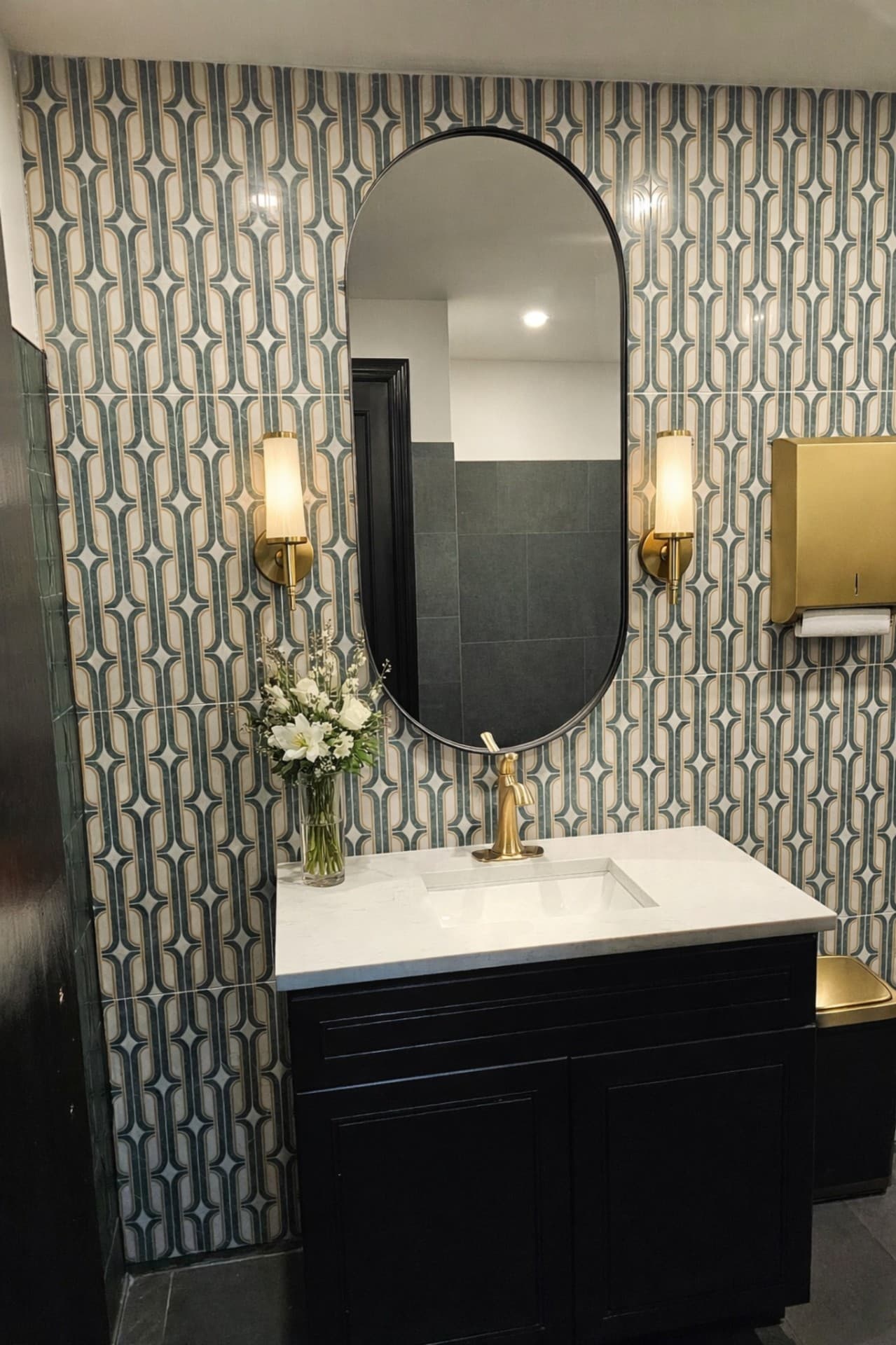Prego Pasta House restroom vanity with pattern tile and brass sconces Greenville Ave Dallas TX