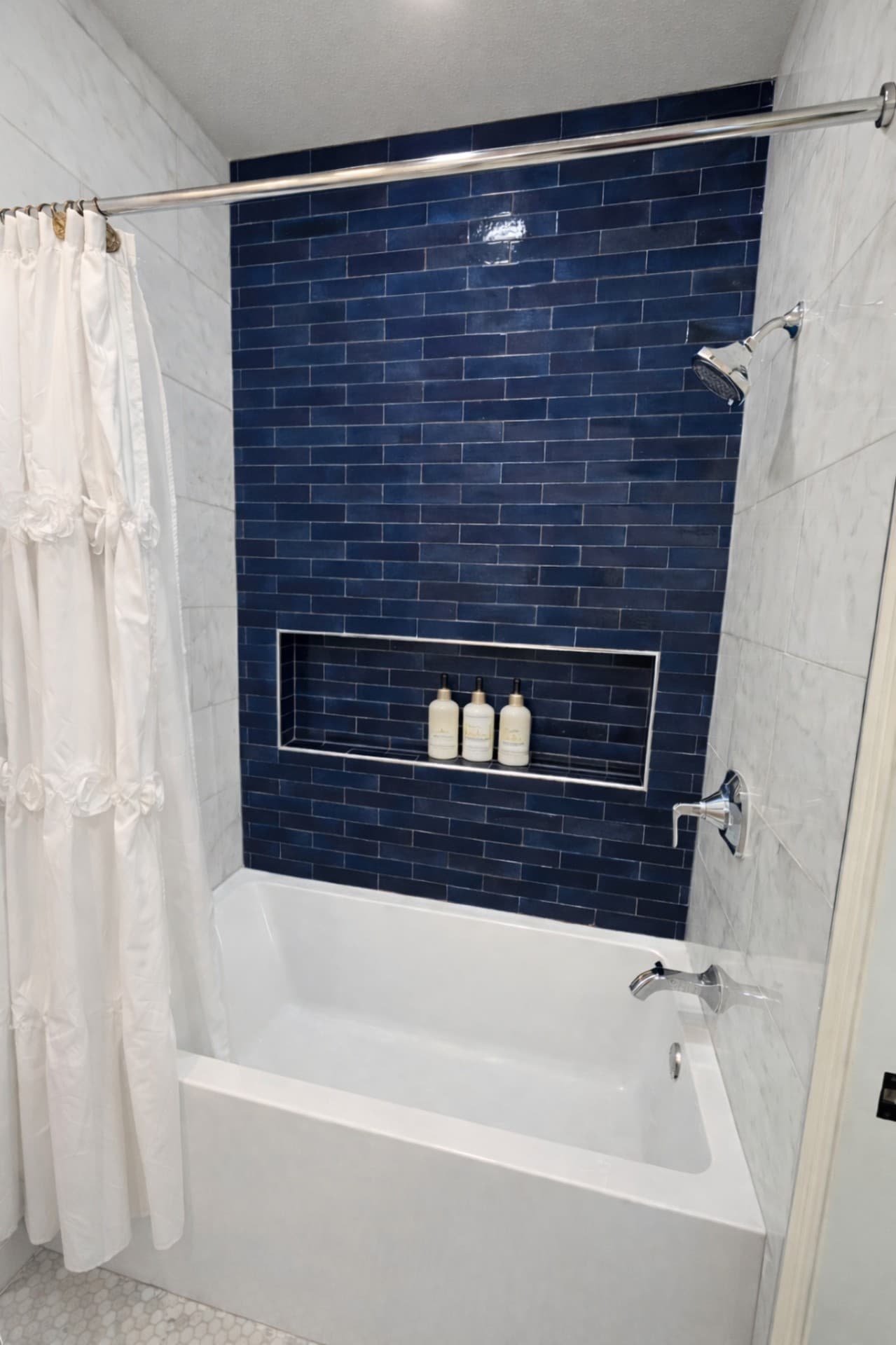 The Colony TX addition bathroom with blue subway tile tub shower and niche