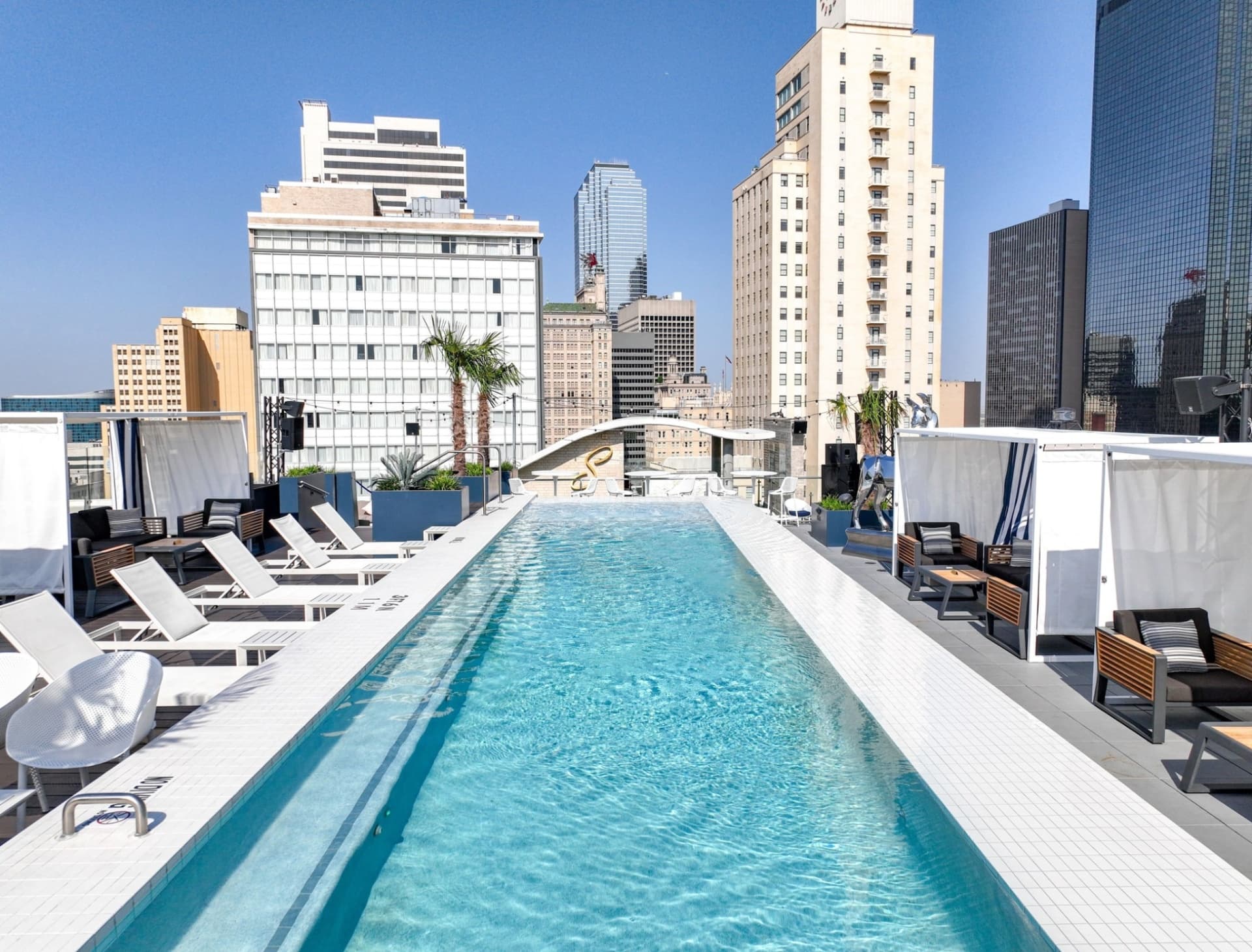 Waterproof rooftop pool with cabanas and downtown Dallas skyline