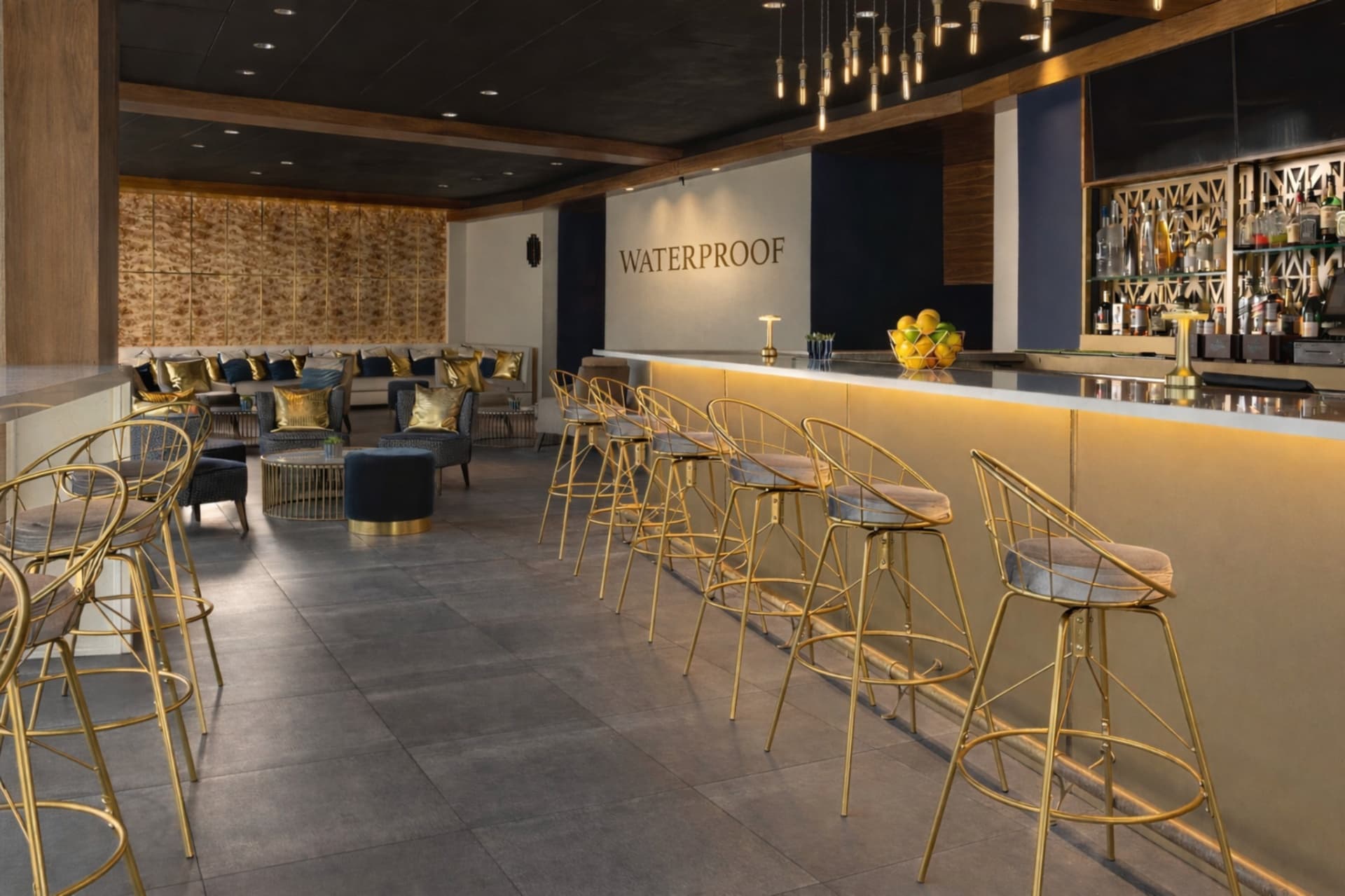 Waterproof rooftop bar interior with gold stools and lounge seating Statler Hotel Dallas TX